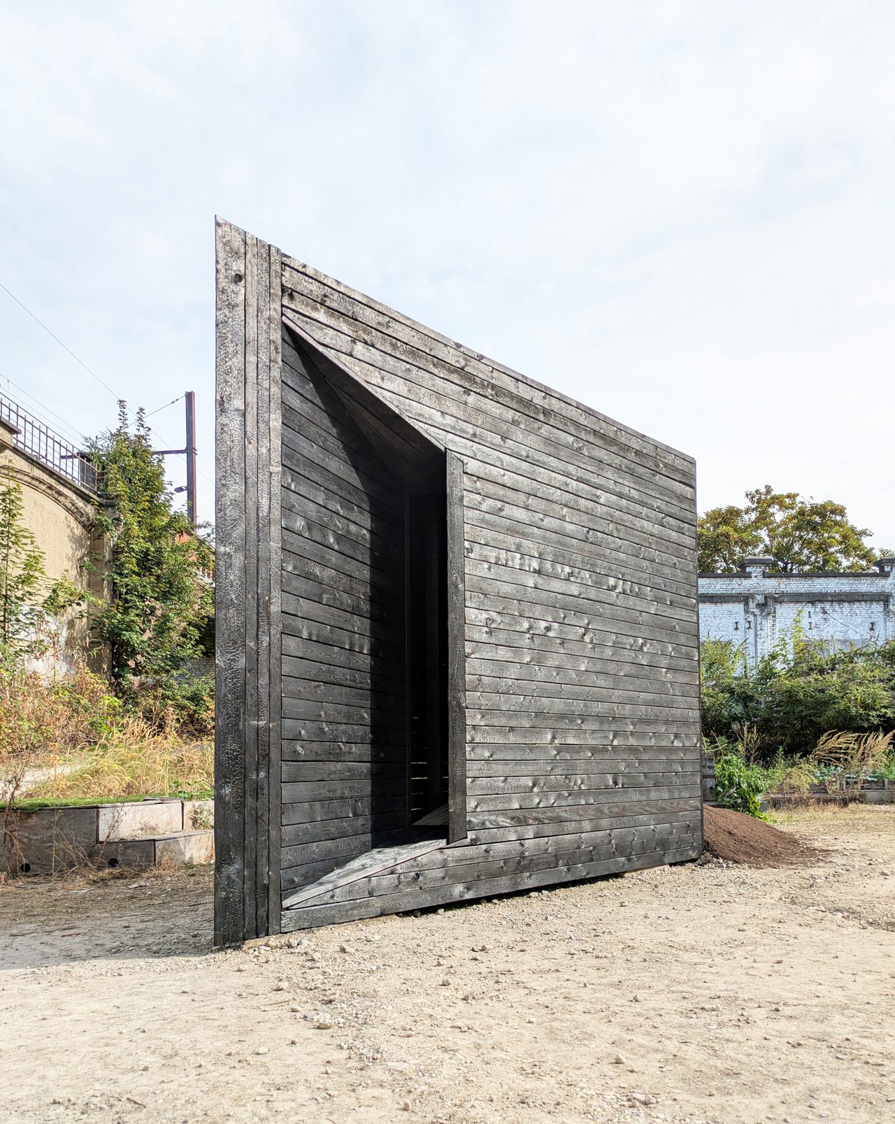 Plough Chapel, a wedge-shaped charred-timber chapel, in the courtyard of La Fabriek, Anderlecht, Brussels