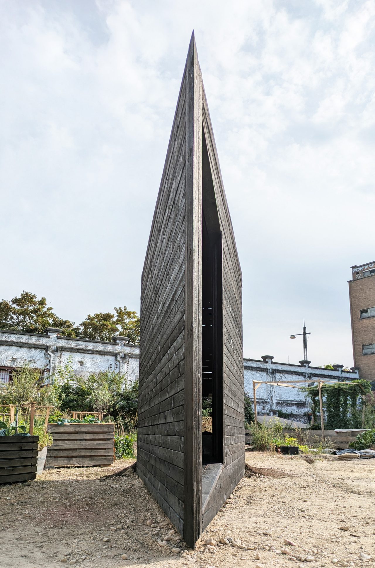 The sharp charred-timber point of the plough-shaped chapel